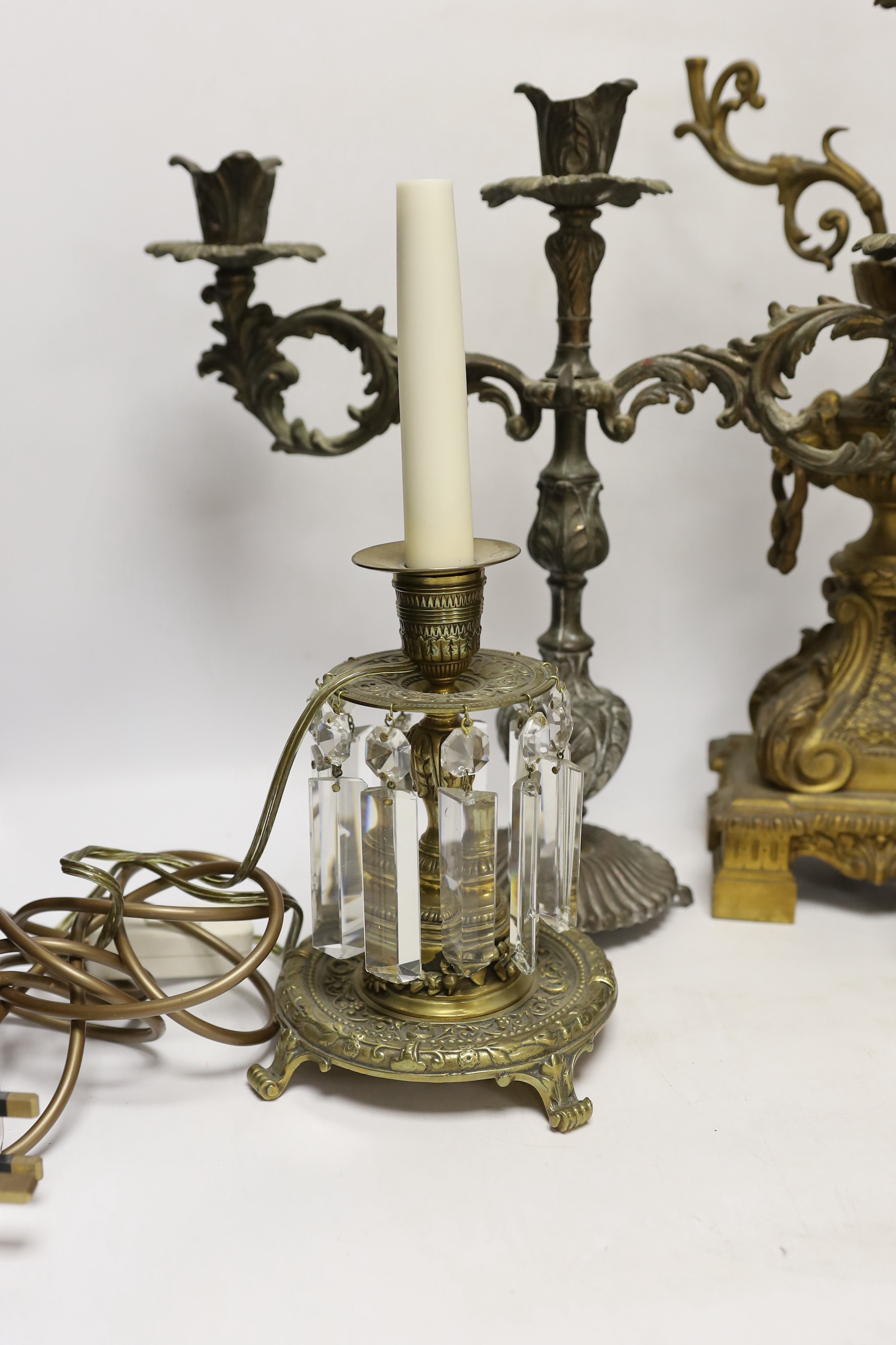 A pair of brass lustre drop candlesticks, lamp base and three branch candelabra, 59cm high